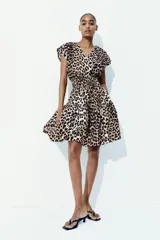 Vestido corto sin mangas en tejido fresco de algodón con estampado animal print. Modelo con escote cruzado en V, pliegues en los hombros, cintura fruncida y pollera con vuelo.