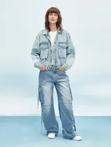 Campera de jean celeste con efecto lavado, corte cropped, cuello camisero, cierre frontal con botones metálicos, cuatro bolsillos frontales con solapa y puños abotonados.