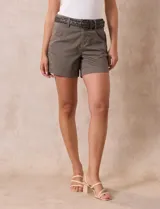 Short de jean azul oscuro con pretina con pasadores, botón y cierre. Delantera con bolsillos. Botón en bolsillos traseros. Incluye cinturón trenzado marrón con hebilla redonda dorada.