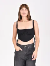 Top negro con corte irregular, breteles anchos y lazos laterales.