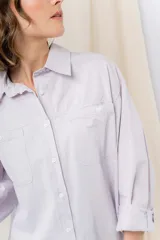 Camisa color crema de algodón liviano, calce oversize, con cuello camisero, cierre abotonado, mangas largas con opción de arremangado y dos bolsillos frontales con solapa.