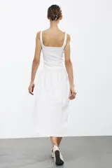 Vestido midi rojo de escote cuadrado y tirantes anchos. Detalle de bajo redondeado en tejido combinado a tono.