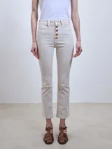 Jeans rectos color crema con diseño clásico y detalles de botones en la parte frontal.