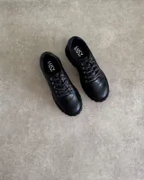 Zapatos acordonados de cuero vacuno color negro, con suela track.