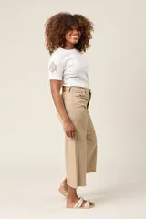 Pantalón jean corte culotte color beige, con tiro alto, bolsillos delanteros y traseros, y terminación desflecada.