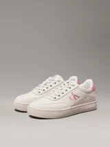 Zapatillas bajas Calvin Klein Jeans color crema con logo CK rosado en el lateral y detalle rosado en el talón.