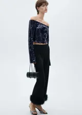 Blusa corta de fiesta con lentejuelas azul marino, hombros descubiertos y mangas largas acampanadas.