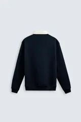 Sudadera azul marino de corte regular con cuello polo blanco de solapa y cierre frontal de botonadura oculta.