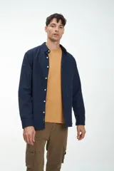 Camisa de manga larga confeccionada en tela de algodón color bordó, con bolsillo en el pecho y botones personalizados.