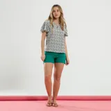 Blusa con estampado de flores en tonos azules y verdes sobre fondo blanco, con corte suelto y cuello redondo.