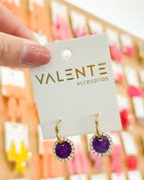 Aros colgantes con argolla dorada y dije circular forrado en tela color violeta con borde de strass plateado.
