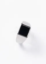 Anillo plateado de acero quirúrgico con piedra negra rectangular en el centro.
