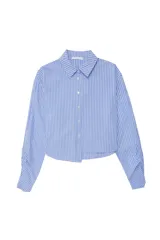 Camisa celeste a rayas verticales blancas, de popelina asimétrica y manga larga.