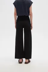 Pantalón de jean color beige, de corte flare y tiro alto, con terminación desflecada.