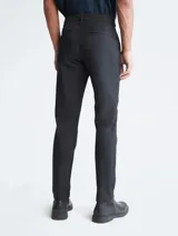 Pantalón chino de corte slim color negro, con bolsillos laterales y traseros, cierre con cremallera y botón, y trabillas para cinturón.
