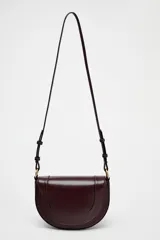 Bolso de hombro ovalado color negro, con asa de doble tira redonda con detalles metalizados dorados. Cierre imantado. Asa de bandolera extraíble con tejido a contraste. Bolso interior con cierre mediante cremallera metálica.