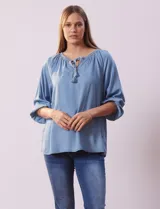 Blusa celeste de tencel, marca Marissa Olivia, con cuello a la base, escote en V con aplique de cordel y lazo de ajuste. Manga larga amplia con puño elastizado.