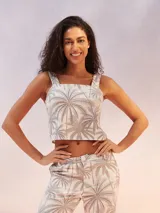 Musculosa corta blanca con estampado de palmeras en tonos grises.