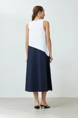 Maxi vestido bicolor, blanco en la parte superior y azul marino en la falda, sin mangas y con escote en V.