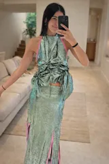 Vestido largo de fiesta color verde esmeralda con detalles en rojo. El top es de escote halter con jaretas y la falda es larga con aberturas laterales.