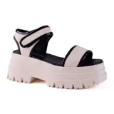 Sandalias con plataforma color blanco hueso, con tiras anchas en empeine y tobillo, con detalles en charol negro.