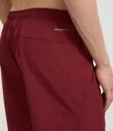 Bermuda deportiva color beige, de tejido plano de poliéster, con cintura elástica y cordón de ajuste. Posee bolsillos laterales con cierre y recortes laterales con perforaciones.