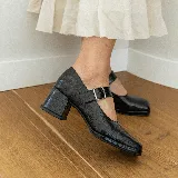 Zapato Mary Jane de cuero vacuno negro con hebilla plateada, punta cuadrada y taco cuadrado.