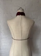 Top halter de color borgoña con detalle de lazo en el frente y espalda descubierta.