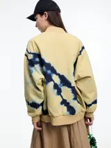 Campera bomber verde con estampado tie-dye en azul marino, cierre frontal y puños y cintura elastizados.