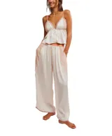Conjunto de pijama de satén color crema, compuesto por un top sin mangas con escote en V y detalles de encaje rosado, y un pantalón palazzo con cintura elastizada y detalles de encaje rosado en los laterales.