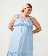 Vestido largo celeste de viscosa, con escote redondo, tirantes anchos con volantes, fruncido en el busto y volado en el ruedo.