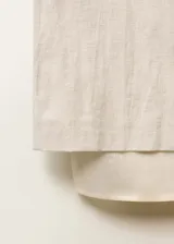 Falda midi color crudo, de corte recto y tiro medio. Presenta un forro interior visible de ramio y cintura con goma elástica.