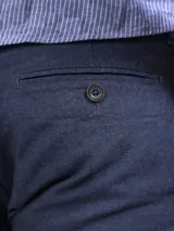 Bermuda color beige claro, de corte casual y largo por encima de la rodilla, con bolsillos laterales.