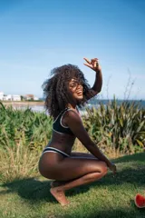 Bikini negro con ribetes blancos, compuesto por un corpiño deportivo con logo y una bombacha de corte clásico.