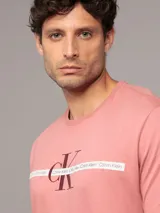 Remera manga corta color salmón de algodón, con cuello redondo y logo de Calvin Klein estampado en el pecho.