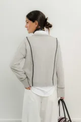 Saco de lana italiano azul con cuello en V, cierre con botones y ribetes en contraste.