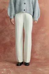 Pantalón de tejido de punto color crudo, de corte recto y tiro alto, con costuras verticales en el frente.