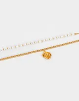 Collar corto dorado de doble cadena, una de perlas y otra de eslabones gruesos, con dije de flor.