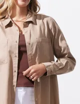 Camisa blanca de lyocell, marca Dash. Tiene cuello con solapa, abertura central con botones, mangas largas regulables con presilla y botón, y dos bolsillos delanteros aplicados.