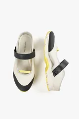 Zapato de cuero sintético color verde oliva y negro, con suela track blanca y tira de velcro en el empeine.