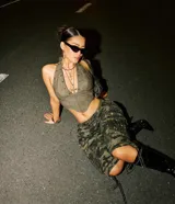 Top corto color verde militar, con escote halter y detalle de tachas plateadas.