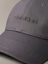 Gorra de béisbol de algodón color gris oscuro, con visera curva y logotipo de Calvin Klein bordado en tono a tono en el frente.