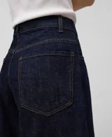Pantalón de denim azul oscuro de pierna ancha, tiro alto, cinco bolsillos, pespuntes a contraste y bajos sin dobladillo.