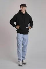 Buzo negro con capucha y bolsillo tipo canguro.