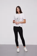 Remera blanca con estampado de hojas de ginkgo biloba en tonos naranja, beige y gris.