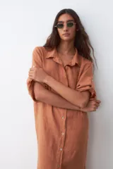 Vestido camisero color ocre de lino, con cuello clásico, mangas 3/4 con botón para sujetar y cierre frontal con botones.