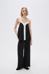 Musculosa de poliéster con breteles finos, diseño color block, corte holgado, escote en V y elástico en el ruedo.