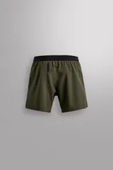 Shorts deportivos color verde oliva confeccionados en tejido técnico ligero y elástico. Cuenta con forro interior, cintura elástica ajustable con cordón, bolsillos laterales, bolsillo de seguridad en espalda con cierre de cremallera, bajo con aberturas laterales y logo estampado en la pierna.