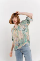 Blusa con estampado único, cuello mao, abertura frontal y mangas 3/4.