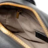 Cartera chica de símil cuero graneado color negro, con doble asa corta y correa larga regulable. Tiene cierre superior, un bolsillo interno con cierre y otro abierto. El interior es de tela de algodón y poliéster.